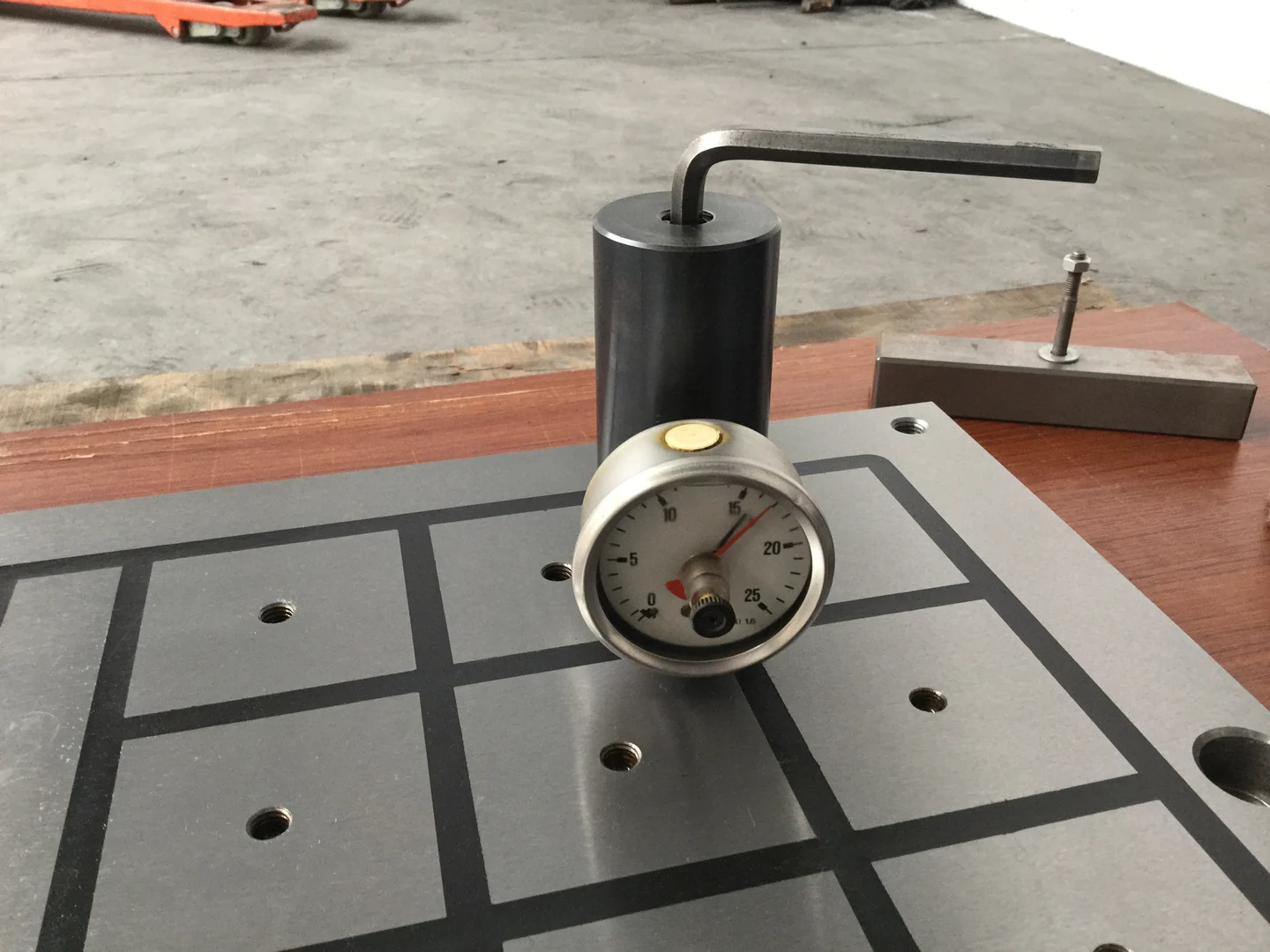 A pull force gauge and test piece on a magnetic chuck working face