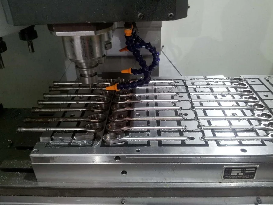 A row of similar steel components held on a magnetic chuck during machining